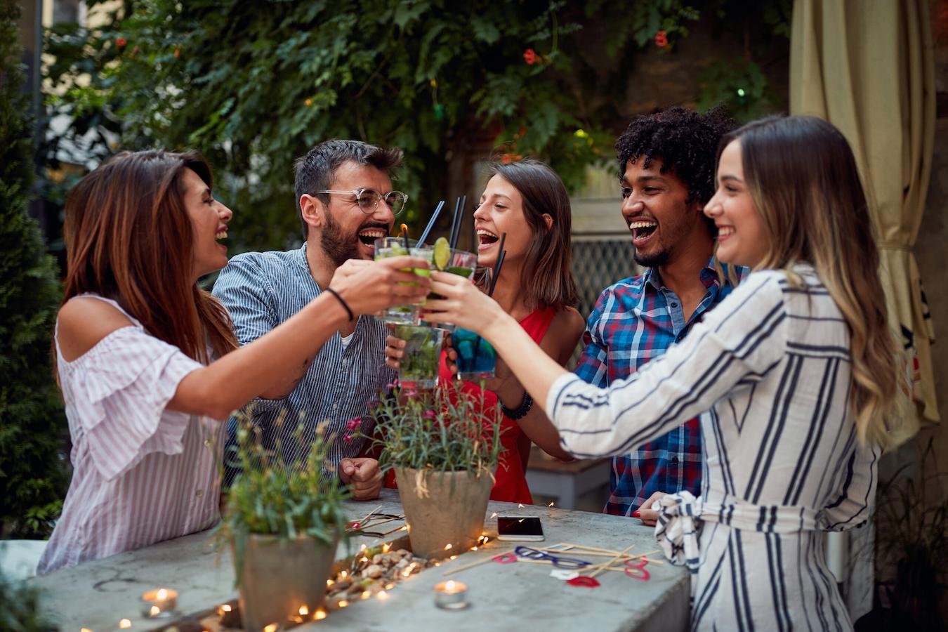 a group of people at an function outdoors drinking from glasses improve employee morale problem solving skills online gatherings increase productivity amusement park mini bonuses summer hard work workplace party party celebrated weekend contributions party employees