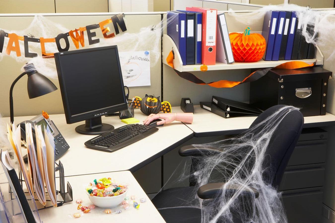 an office cubicle decorated with Halloween items charcuterie board treat bags raise money company logo