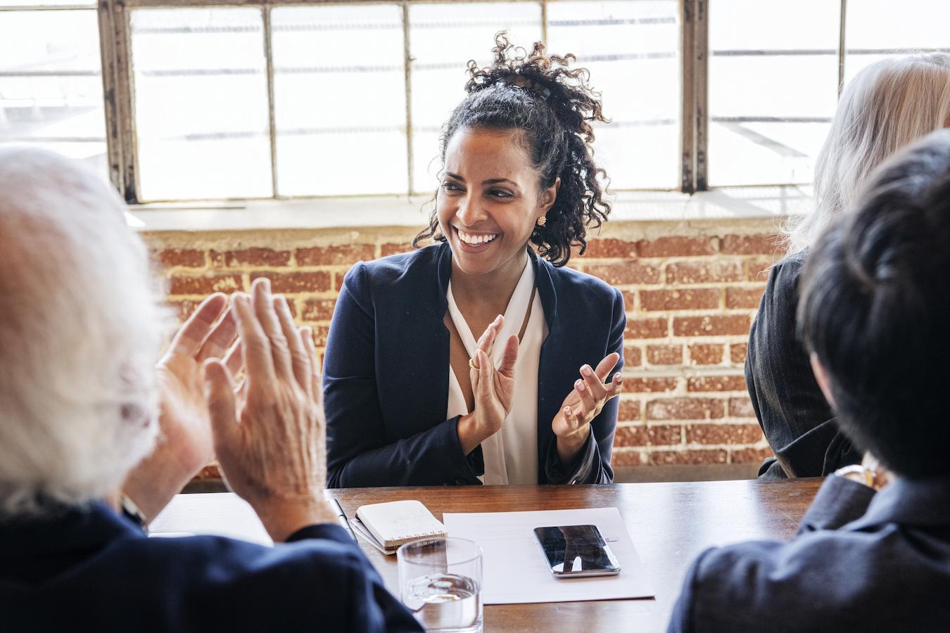 Employees clap after a successful meeting