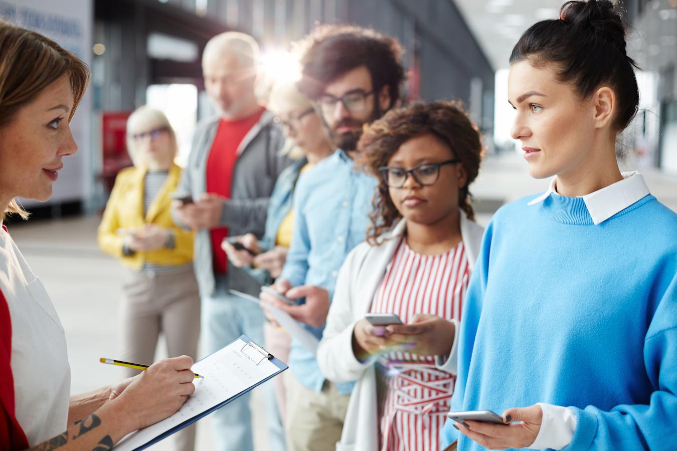 Event manager who runs their own business and holds a bachelors degree stands in front of six other planners who collaborate on event manager jobs