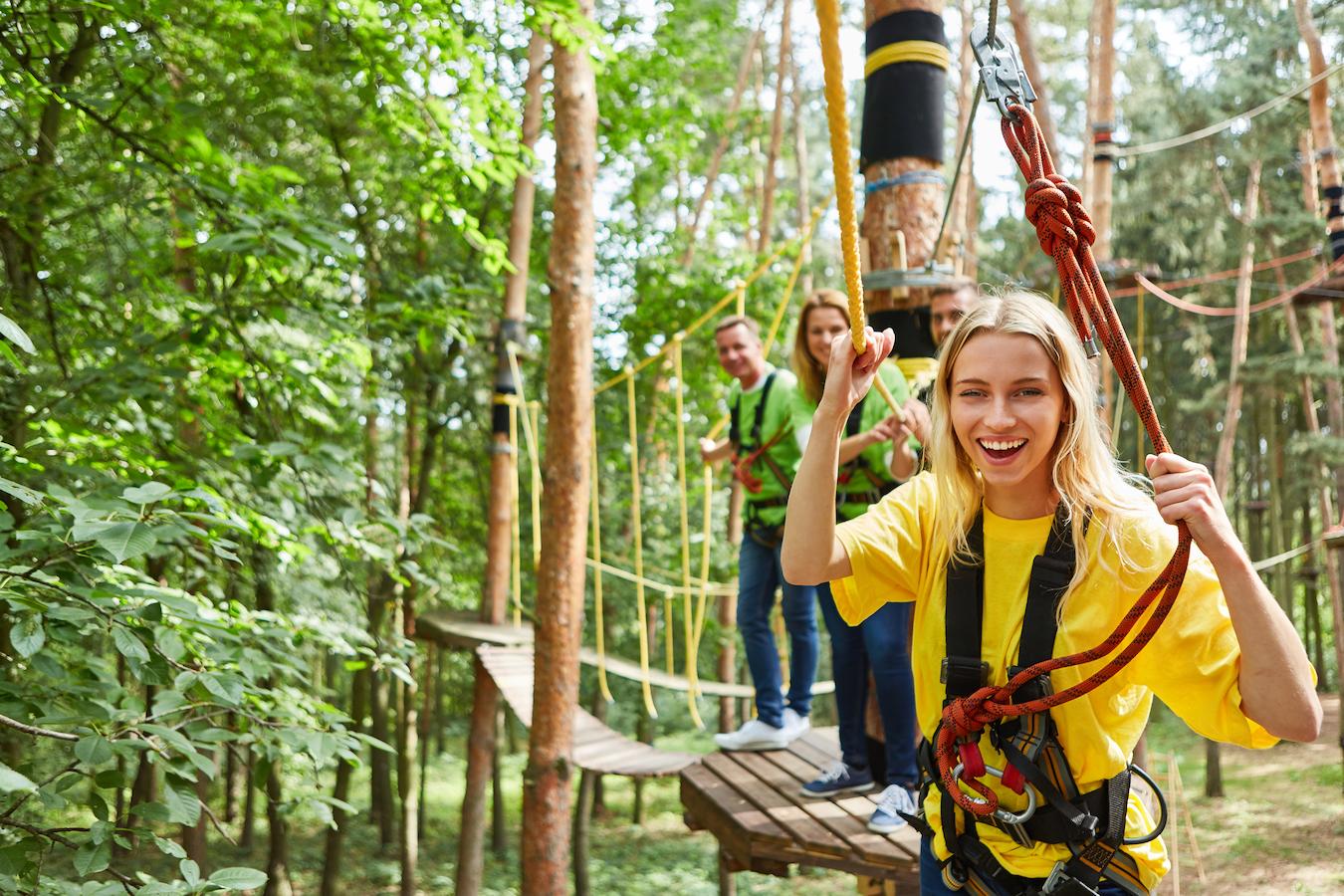 Four colleagues smile at outdoor ropes course