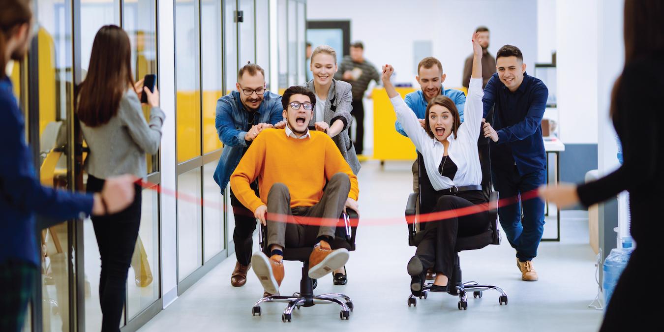 group of employees playing games and laughing at the office remote workers many employees return to the office in person employees office ideas office fun activities online platform other teams video challenges individual employees dance party event planning
