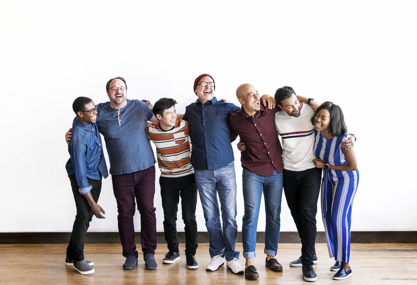 Group of people laugh and embrace