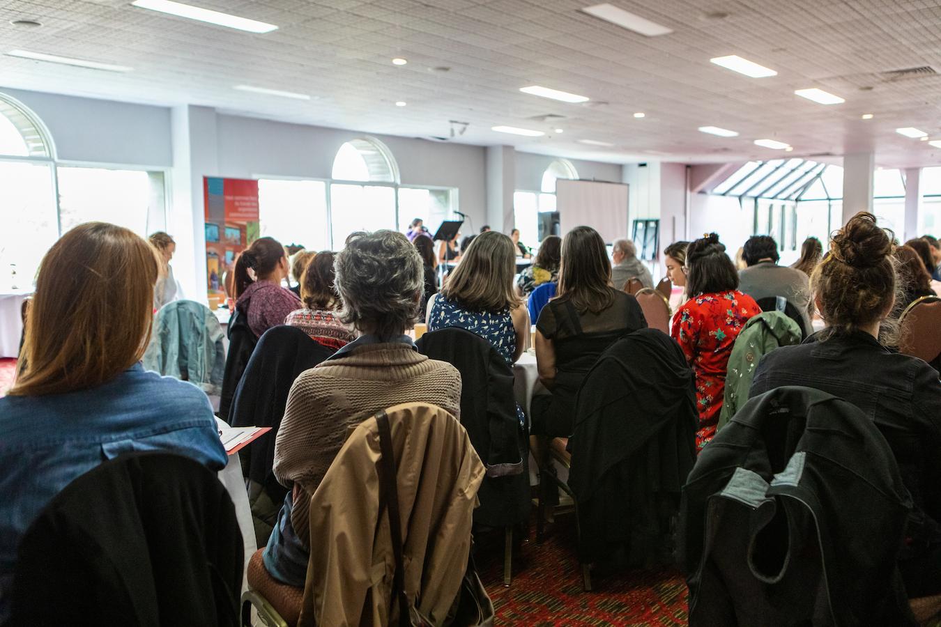 Large crowd face panel and listen to speakers