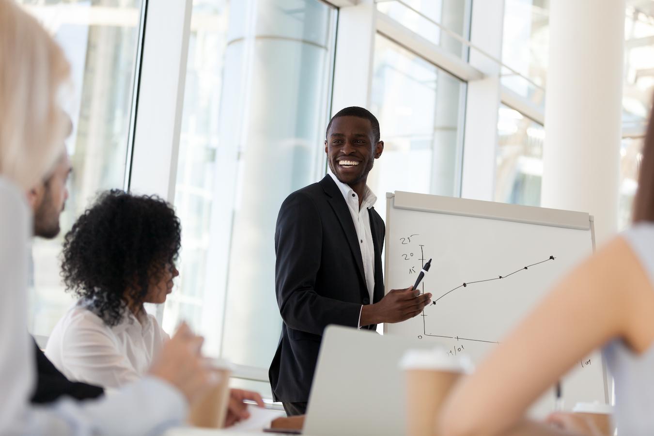 Man laughs in front of graph