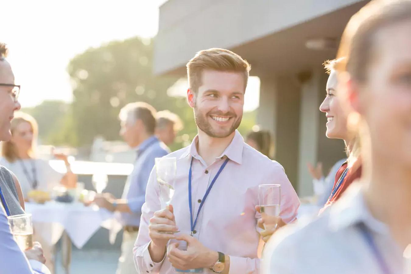 man smiling in a group of people wearing name tags conferences networking crowd important place customers main reason success connect own event benefits attendees community brand business benefit events