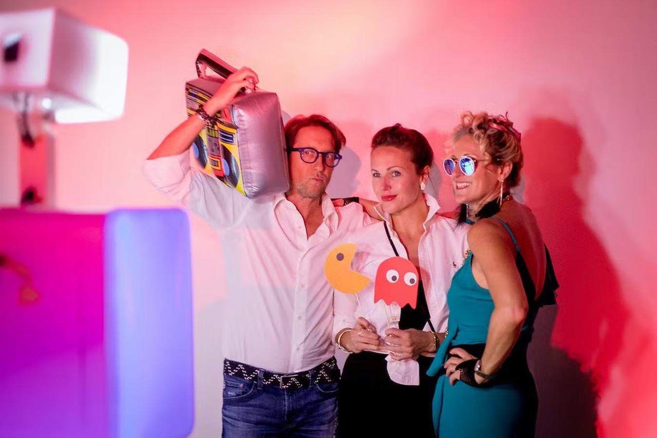 people dressed in 80s attire in a booth circus tent dance floor next event ideas hollywood theme dance party event goers guests arrive