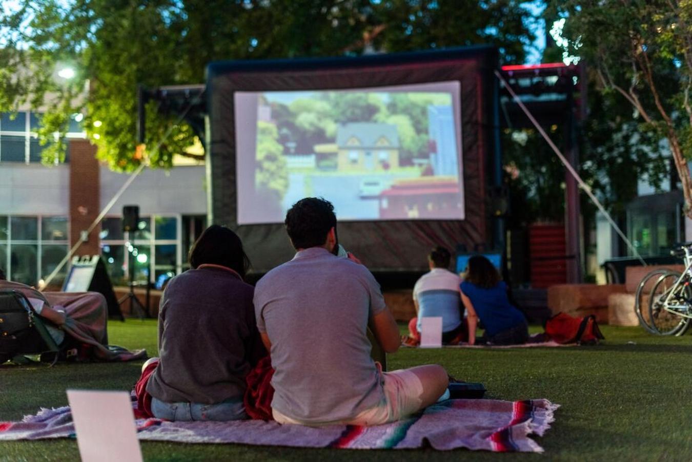people sitting outside at an outdoor movie screening halloween party ideas work tasks decorate kids theme party candy party murder mystery
