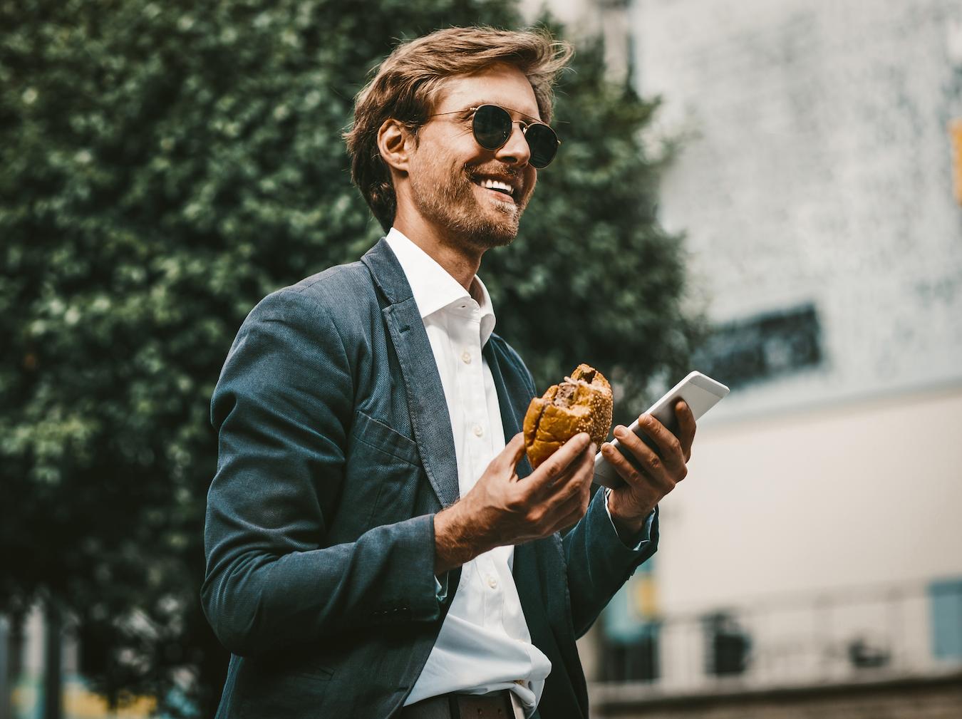 Person in blue blazer and sunglasses stays calm and smiles while taking a helpful outdoor break from the stresses of work life