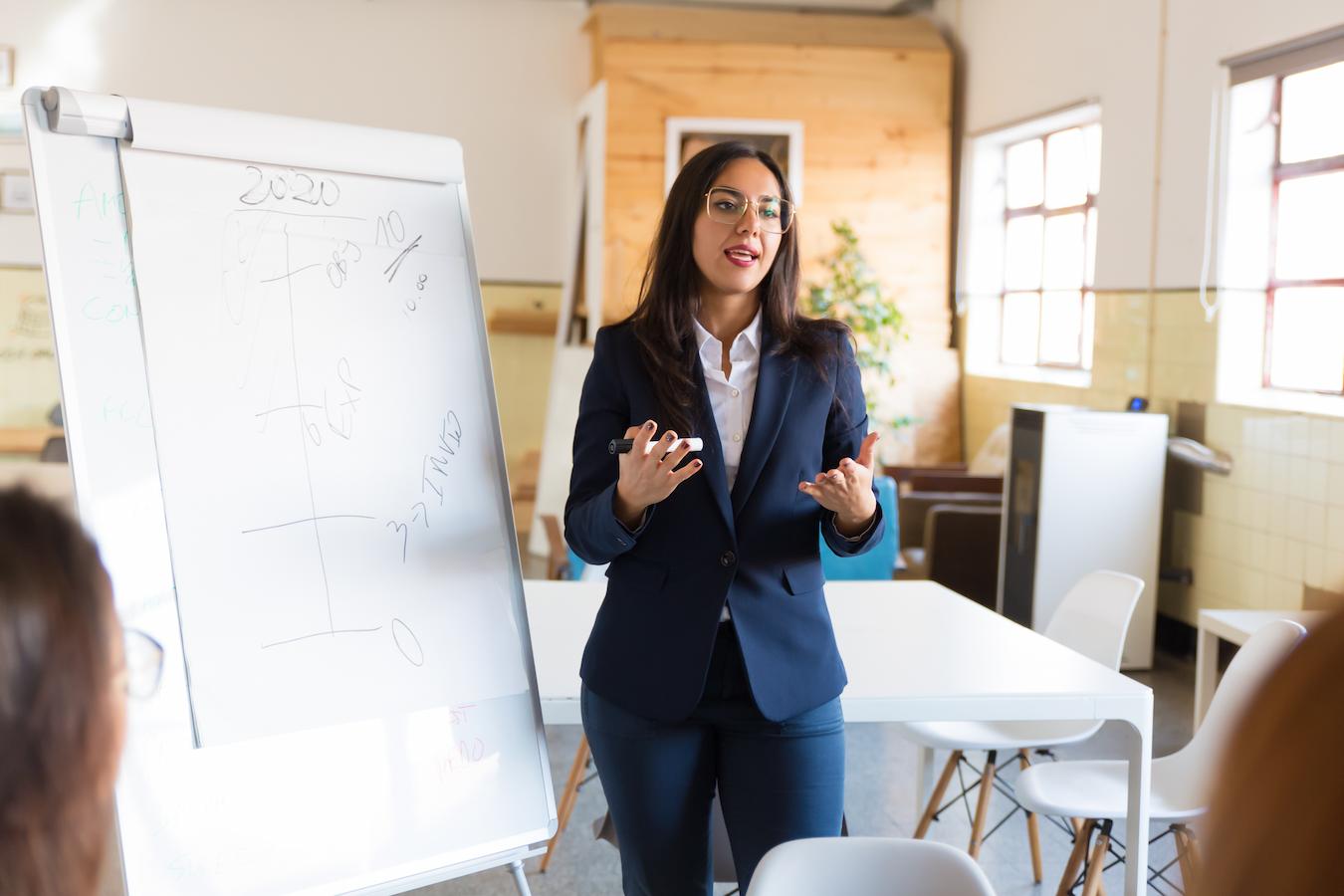 Person in suit uses chart as example to talk about company trends that can impact the present and future of the business
