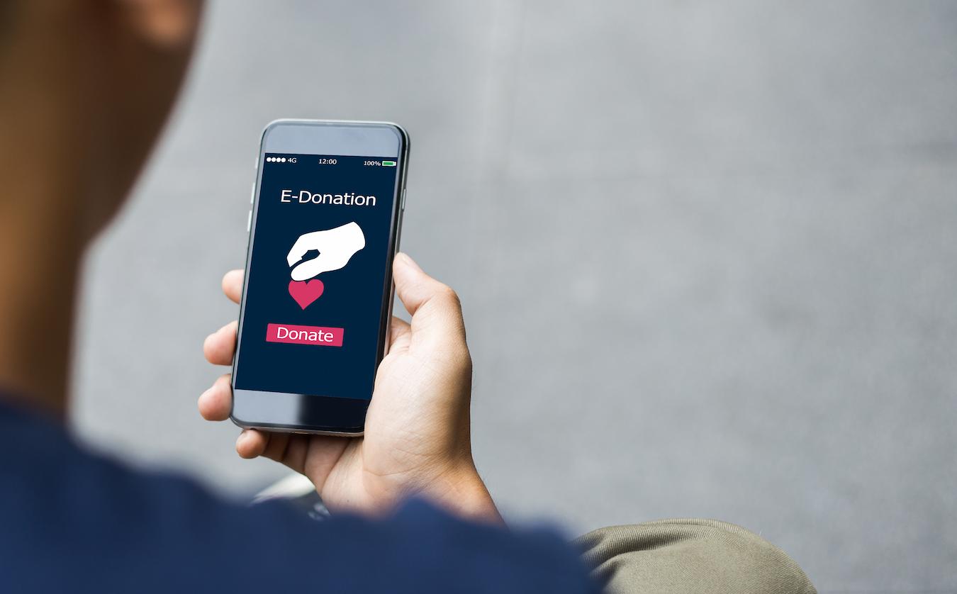 Person participates in virtual fundraiser by using online tools to make a donation to the online fundraiser