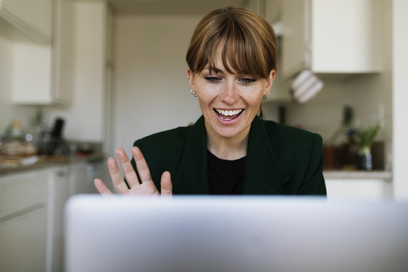 Person waves at employees over computer screen