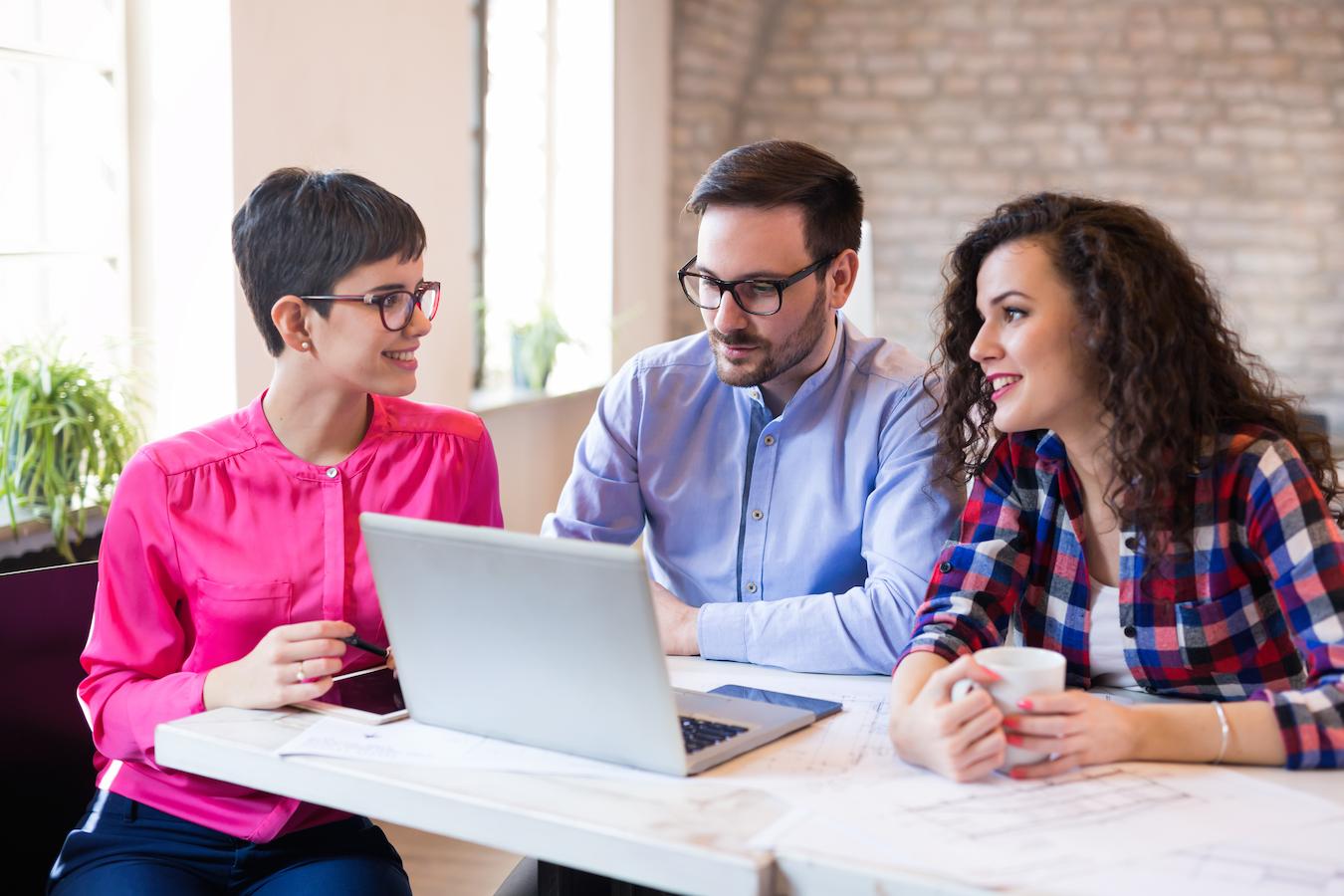 Three colleagues measure employee productivity and review customer feedback at a computer
